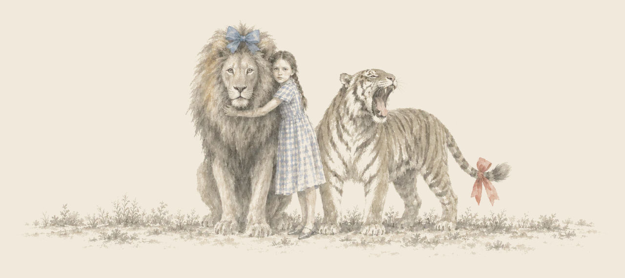 Dorothy hugs the Cowardly Lion, who wears a blue bow on his head, while the Hungry Tiger beside them roars, a red bow on his tail.