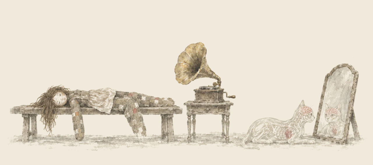 The Patchwork Girl lies limp on a bench beside a phonograph, while the Glass Cat lies before a tall mirror, looking at herself.